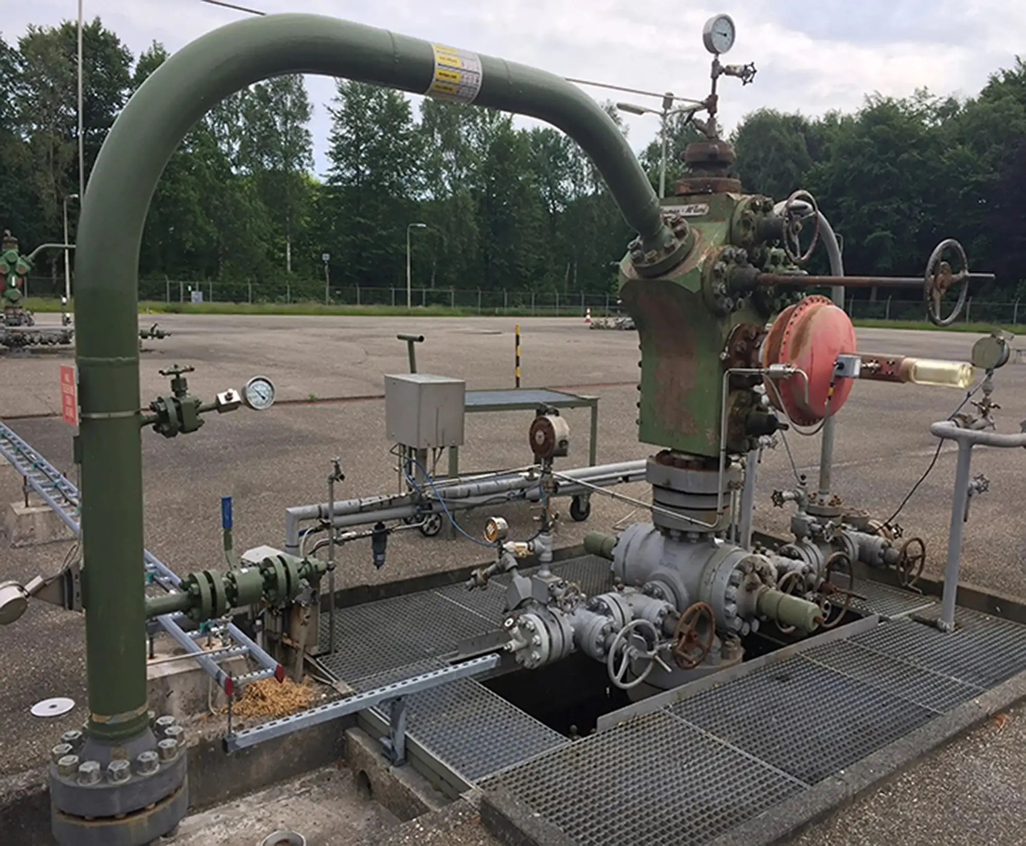 NAM natural gas production wellhead with valves, pressure gauges and flowline equipment in the Netherlands.
