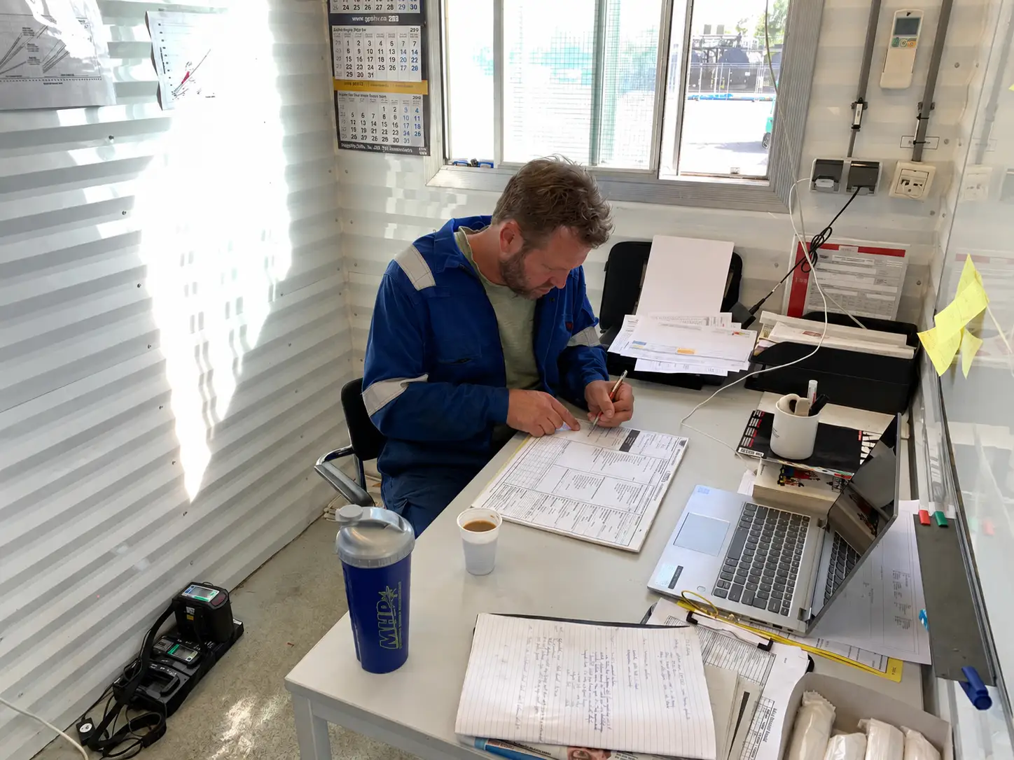 Schooner Energy oilfield operations professional reviewing drilling and well documentation at a worksite